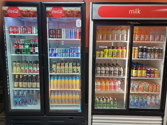 Two large coolers stocked with cold drinks and juice